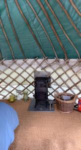 LlangrannogYurt glyncoch isaf farm的一间卧室,配有带炉灶的帐篷