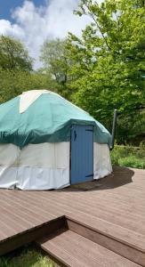 LlangrannogYurt glyncoch isaf farm的圆顶帐篷,在木甲板上设有一扇蓝色门