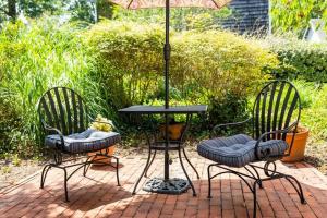 圣迈克尔斯Old Brick Inn的砖砌庭院设有两把椅子和一张桌子及遮阳伞