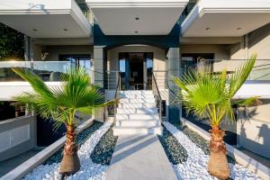 伊拉克里萨Blue Wave Luxury Suites的两棵棕榈树在房子前面
