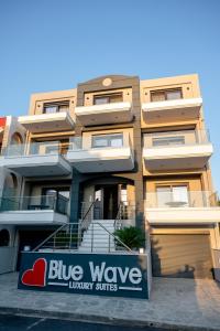 伊拉克里萨Blue Wave Luxury Suites的前方的一栋带蓝波豪华套房标志的建筑