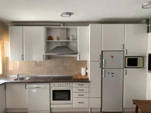 埃尔阿雷纳尔Arenalita的厨房配有白色橱柜和白色冰箱。