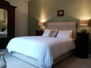 沃伦波因特窄水城堡自助式公寓的一间卧室配有一张带两盏灯的大型白色床。