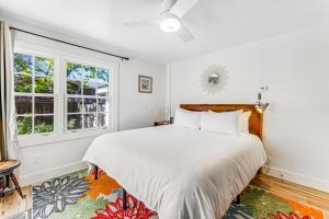 温莎Red Rooster Cottage的白色卧室设有一张大床和两个窗户