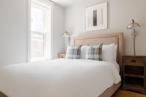 波士顿Sonder The Magnolia的卧室配有带枕头的白色床和窗户。