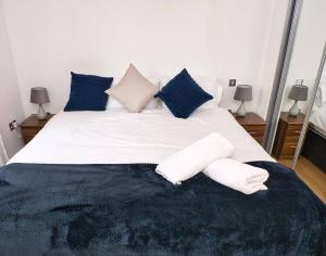 伯明翰Lovely 1 Bedroom Apartment - Bham City Centre的卧室配有带蓝色枕头的大型白色床