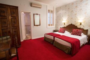 里斯本多姆桑丘一世酒店的酒店客房,配有两张带红色床单的床