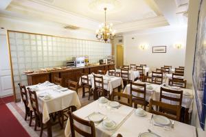 里斯本多姆桑丘一世酒店的餐厅设有白色的桌椅和柜台