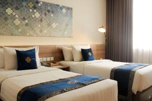 芝卡朗Antero Hotel Jababeka的酒店客房 - 带两张带蓝色枕头的床