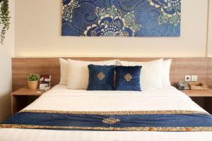 芝卡朗Antero Hotel Jababeka的一间卧室配有一张带蓝色和白色枕头的床