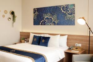 芝卡朗Antero Hotel Jababeka的一间卧室配有蓝色和白色床单
