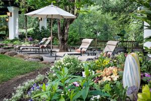 纳帕纳帕谷烛光酒店的花园设有椅子和遮阳伞,鲜花盛开