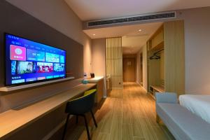 滨海新区天津滨海东方智选假日酒店的酒店客房的墙上设有大屏幕平面电视。