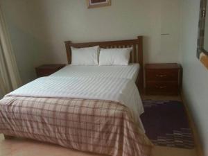 姆巴拉拉The Greenville Home的卧室内的一张带白色床单和枕头的床