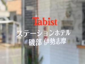 志摩市Tabist Station Hotel Isobe Ise-Shima的窗口上写有亚洲文字的标志