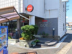 志摩市Tabist Station Hotel Isobe Ise-Shima的建筑物一侧有标志的商店