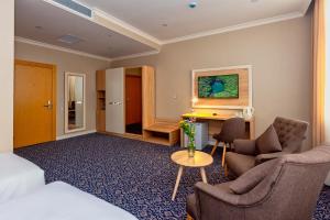 巴库Golden City Hotel Baku的酒店客房,配有一张床、一张桌子和椅子