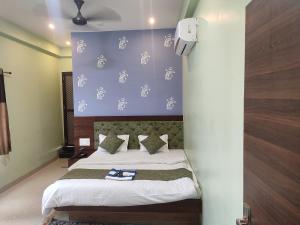 MaheshwarHotel shivalay palace的一间卧室设有一张床和蓝色的墙壁