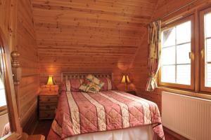 Ardlui阿德卢伊洛赫赛德山林小屋的小木屋内一间卧室,配有一张床