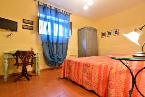 Vaglio di BasilicataAgriturismo La Dimora dei Cavalieri的一间卧室配有一张床、一张桌子和一个窗户。
