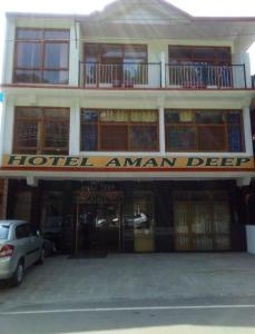 达兰萨拉Hotel Amandeep的大楼前的安曼标志