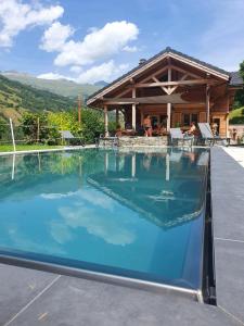 圣莫里斯堡Chalet savoyard d'exception avec piscine chauffée的房屋前的游泳池