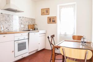 布里尼奥勒Maison Sumiane的厨房配有白色橱柜和桌椅