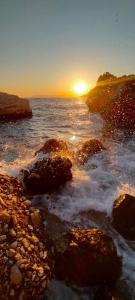 德朗西斯Apartment Croatia Art的海上的日落,岩石在水中