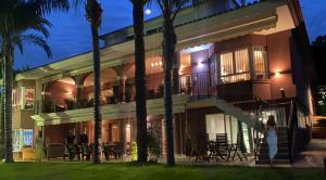 穆特克萨梅尔10 Bedroom 5 Star Luxury Villa & Heated Pool for 5 to 30 Guests near Alicante的一位妇女,晚上站在建筑物前