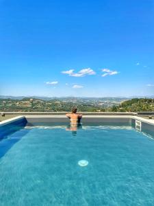 佩鲁贾普鲁萨酒店的坐在游泳池边欣赏风景的人