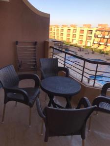 艾因苏赫纳Cozy Chalet in El Ain El Sokhna شالية بالعين السخنة的阳台上的一组桌椅