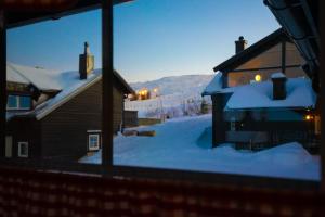 特吕西尔Fagertoppen 12B的从雪中房子的窗户上可欣赏到风景