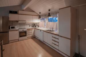 特吕西尔Fagertoppen 12B的一间设有白色橱柜和窗户的大厨房