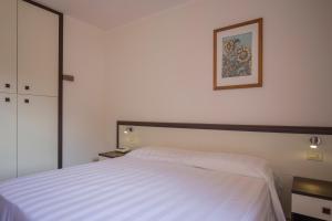 费拉约港发布易斯雅酒店的卧室配有白色的床,墙上挂着一幅画