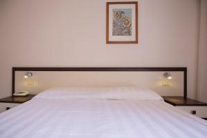 费拉约港发布易斯雅酒店的卧室配有一张带两张桌子的大型白色床