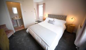 RoagTigh Beag Na Mara的卧室配有白色大床和水槽