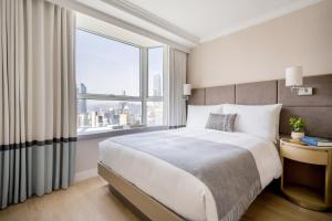 香港麦当劳道贰号酒店式服务住宅公寓的一间卧室设有一张大床和一个大窗户