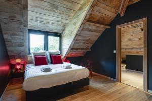 弗朗科尔尚Le Moulin Noir à 400m du circuit的一间卧室配有一张带红色枕头的大床