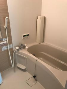 石垣岛cottage SOUL MATE的带浴缸的浴室,旁边设有电话