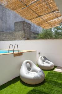 科尔萨诺Villa Franitu - Corsano的两个白色豆袋坐在游泳池旁的草地上