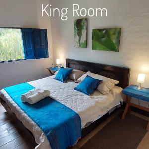 萨兰托Reserva Guadalajara - Cocora Valley的一间卧室配有一张特大号床和蓝色枕头