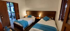 萨兰托Reserva Guadalajara - Cocora Valley的一间卧室配有两张带蓝色枕头的床