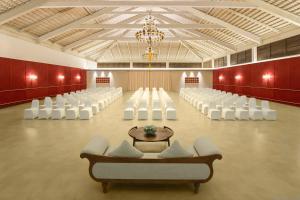 马迪凯里Aurika, Coorg - Luxury by Lemon Tree Hotels的一个带白色椅子和吊灯的宴会厅