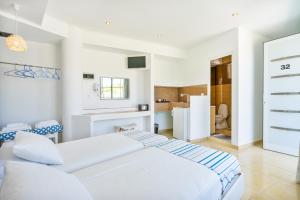 法里拉基Mando Living -Faliraki的一间白色卧室,配有两张床和一台冰箱