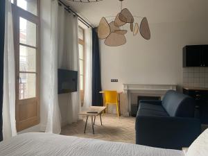 波城Pau's Appart - Pau Centre的一间卧室配有蓝色的沙发和黄色的椅子
