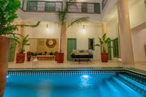 马拉喀什Riad Trésor Marrakech的游泳池,位于带客厅的房屋内
