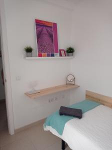拉拉古纳Cañete 4的卧室配有一张床,墙上设有架子