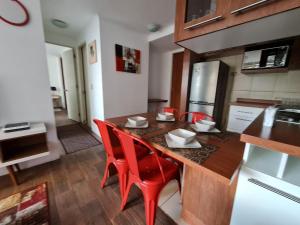 康塞普西翁Departamentos Concepcion Centro的厨房配有带红色椅子的木桌