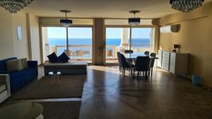 亚历山大Midpoint Sea View - families only的客厅配有蓝色的沙发和桌椅