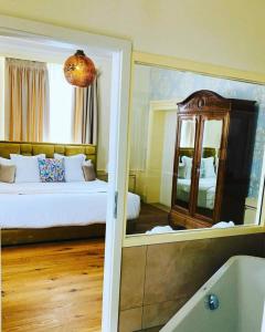 罗蒙La Belle-Croix的一间卧室配有一张床、镜子和浴缸